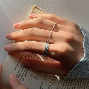 Nahaufnahme eines 925er Sterling Silber Rings mit römischen Ziffern auf einem Buchhintergrund