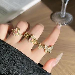 Vista detallada de exquisitos anillos de oro con diamantes rosas y mariposas