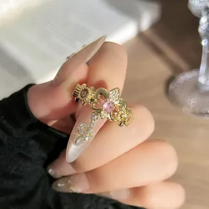 Detalle macro de anillo vintage de flor de lis con piedras rosas y motivo de serpiente
