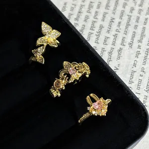 Vista detallada de un set de anillos vintage con mariposa y cristales rosas