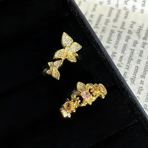 Primer plano detallado de anillos vintage de flor de lis y mariposa en joyero de terciopelo