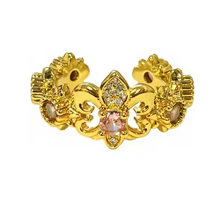 Detalle de anillo vintage de flor de lis dorada con piedra rosa y cristales finos