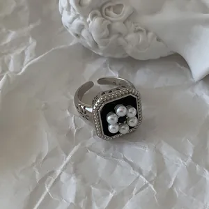 Gros plan d'une bague vintage en argent 925 avec une fleur de perle sur fond noir