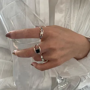 Detailansicht eines geometrischen Ringsets aus S925 Silber mit schwarzem Achat am Weinglas