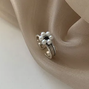 Gros plan d'une bague vintage en argent sterling 925 avec une fleur en perles