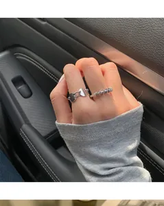 Detailed close-up of vintage twisted silver rings worn on a hand inside a car interior
