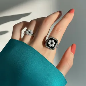 Gros plan sur des bagues vintage en argent 925 avec émail noir et fleurs de perle