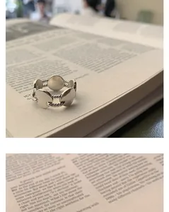 Detailed macro view of a vintage S925 sterling silver twisted rope ring on a book