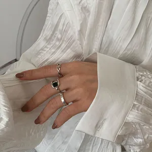 Nahaufnahme eines geometrischen S925-Silberrings mit schwarzem Achat an der Hand