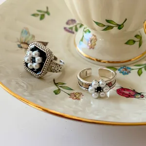 Gros plan détaillé de bagues vintage en argent sterling 925 avec motifs de fleurs en perles