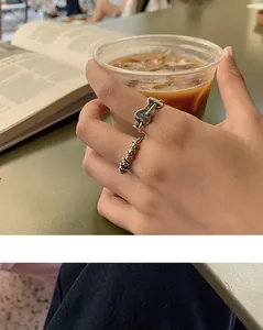 Detailed view of vintage braided 925 sterling silver rings worn while holding coffee cup