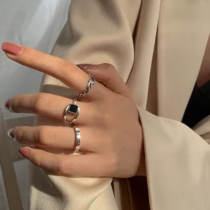 Nahaufnahme minimalistischer S925 Sterlingsilberringe mit schwarzem Onyx an einer Hand.