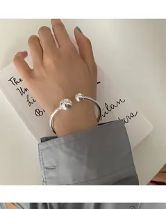 Nahaufnahme eines minimalistischen 925er Sterlingsilber Armreifs mit Doppelball-Design