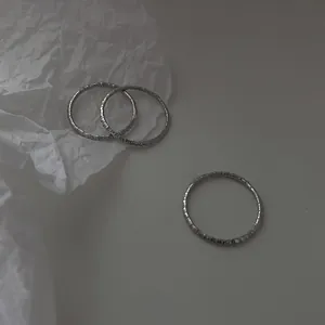 Nahaufnahme von drei Ringen aus 925er Sterlingsilber mit römischen Ziffern.