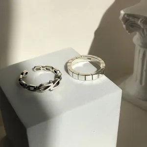 Detailansicht von zwei S925 Sterling Silber Ringen auf einem weißen Steinsockel