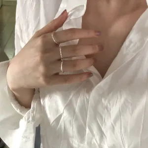 Vista dettagliata di tre anelli minimalisti in argento s925 indossati da una donna