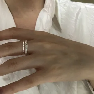 Dettaglio di due sottili anelli in argento sterling s925 indossati su un dito.
