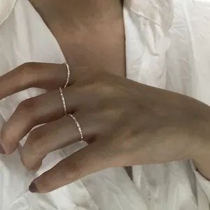 Dettaglio di tre anelli sottili in argento sterling s925 con finitura scintillante
