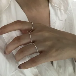 Dettaglio di tre anelli sottili sfaccettati in argento sterling s925 su una mano