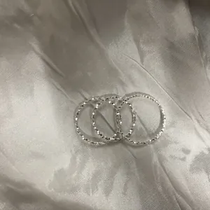 Primo piano di tre anelli in argento sterling 925 con finitura polvere di stelle.
