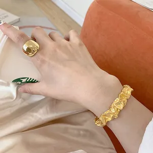 Nahaufnahme der exquisiten Details eines goldenen Armreifs mit unregelmäßiger Textur am Gelenk