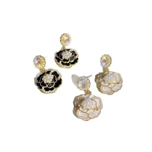 Eleganti orecchini a pendente a camelia bianchi e neri decorati con perle e cristalli