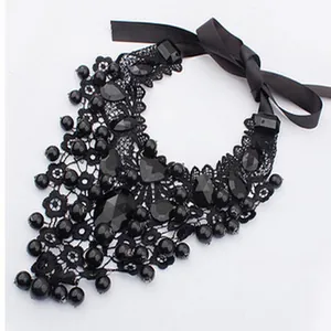 Dettaglio di una collana in pizzo nero fatta a mano con perle e nastro di raso