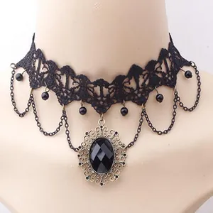 Primo piano di una collana girocollo vintage in pizzo nero con ciondolo in gemma ovale.