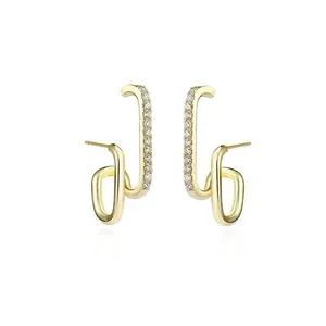 Detail view of minimalist gold J-shaped earrings featuring shimmering pavé cubic zirconia