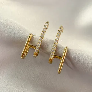 Detailed macro view of gold-tone bar earrings featuring sparkling cubic zirconia accents