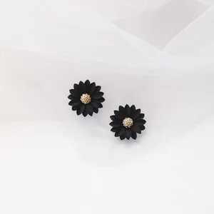 Detailed view of matte black daisy stud earrings featuring a textured golden center