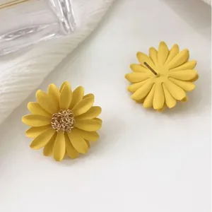 Elegant bright yellow 3D daisy flower stud earrings with an intricate golden center detail