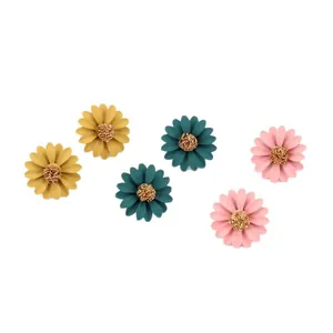 Three pairs of colorful chrysanthemum flower stud earrings in yellow teal and pink