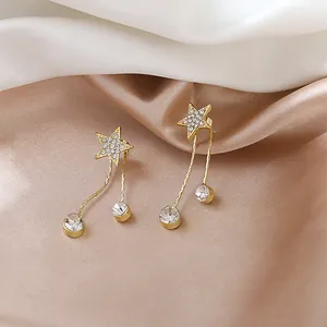 Gros plan détaillé de boucles d'oreilles étoiles dorées élégantes avec strass brillants
