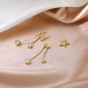 Vue détaillée des boucles d'oreilles étoile dorées avec cristaux de zircone scintillants