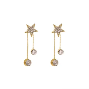 Détail de boucles d'oreilles pendantes étoile dorée avec cristaux clairs pour femmes