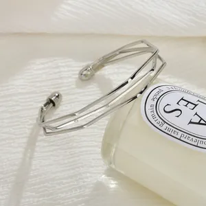 Vue détaillée d'un bracelet jonc ouvert géométrique argenté à trois couches épuré.