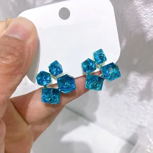 Vista macro di orecchini a lobo 3D in zircone blu con elegante design a cubetto di zucchero