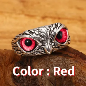 Dettaglio di un anello a forma di gufo vintage in argento con vivaci occhi rossi.