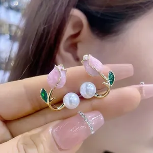 Detailed view of pink tulip pearl earrings with gold-tone finish and fine petals