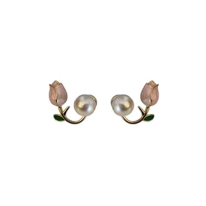 Elegant pink tulip pearl stud earrings with gold-tone branch and green leaf design.