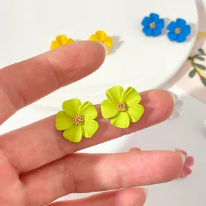 Primo piano di orecchini a lobo a fiore verde lime con dettagli delicati dei petali