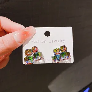 Primo piano dettagliato di orecchini a lobo in zircone cubico colorato su cartoncino