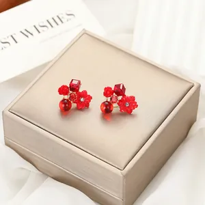 Dettaglio ravvicinato di orecchini vintage a fiore rossi con zircone su scatola
