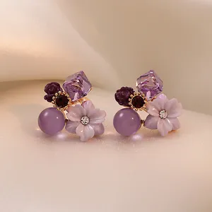 Primo piano di orecchini vintage a fiori viola con accenti in zircone e cristallo