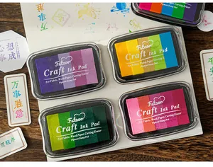 Close-up of four 5-color gradient craft ink pads for DIY stamping on wood surface.