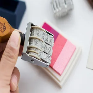 Primo piano di un timbro datario vintage in legno su un cuscinetto inchiostratore rosa
