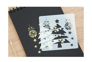 Close-up detail of a reusable Christmas tree painting stencil on a black spiral notebook