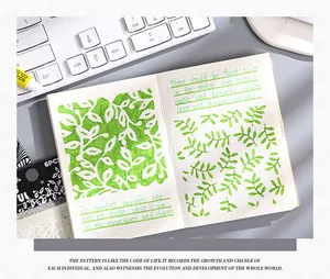 Detail view of green leaf pattern created with vintage PET drawing stencil on a notebook