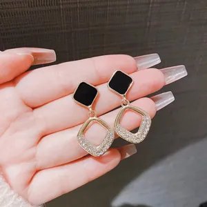 Elegant black geometric drop earrings featuring sparkling crystals on gold alloy